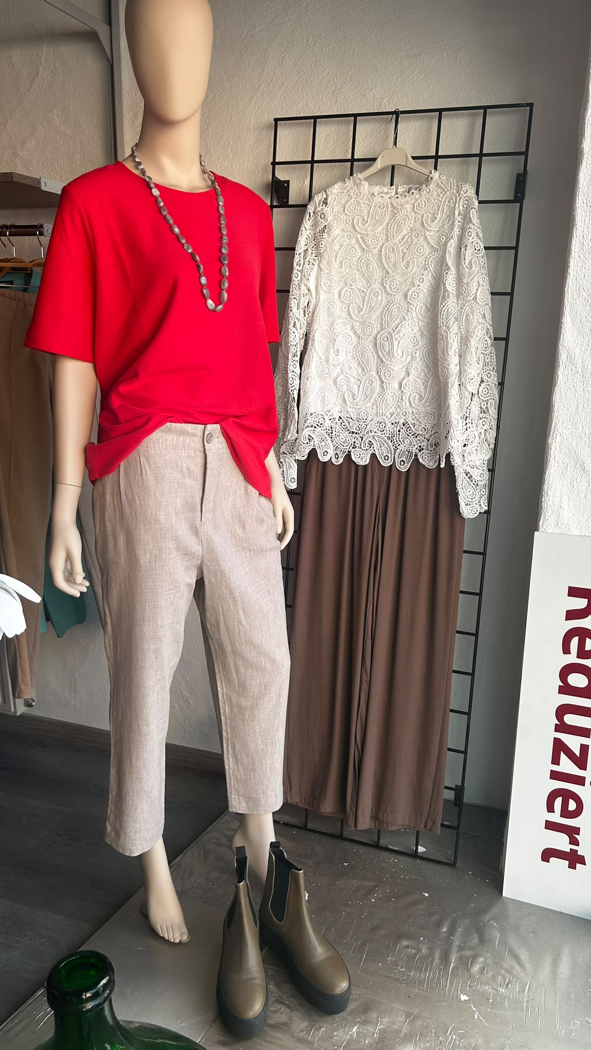 Schaufensterpuppe mit rotem Top, Leinenhose und Spitzenbluse